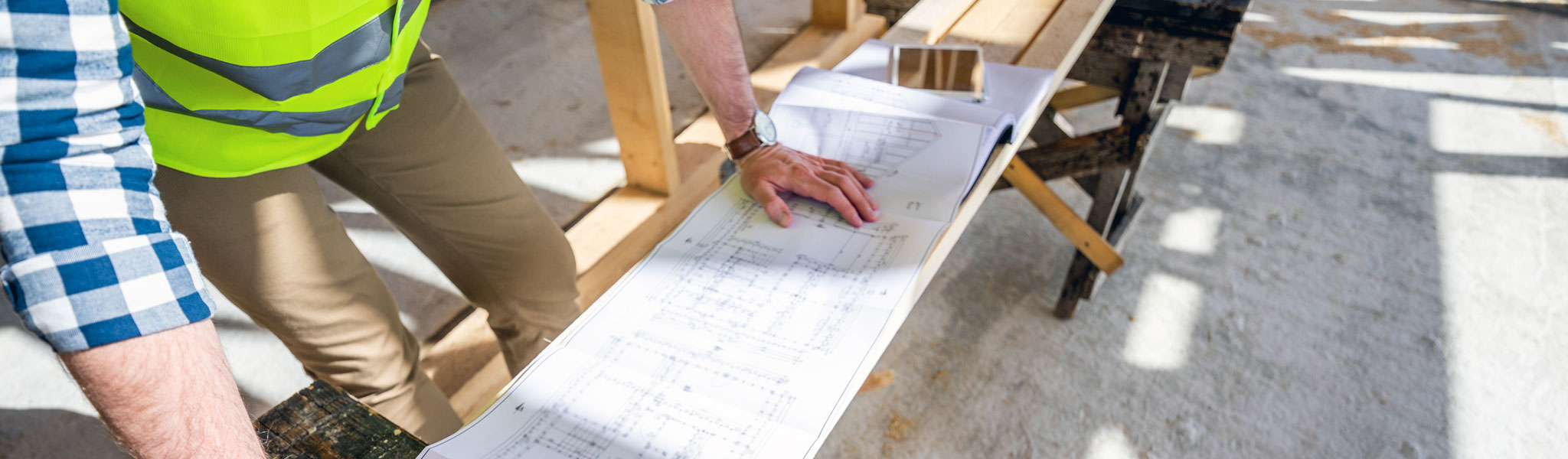 Architect Or Engineer On Construction Site Looking At Blueprints Of Building House, Close Up